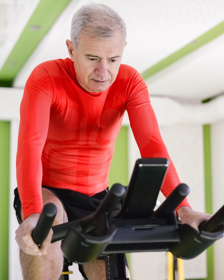 Demo stock image of an older man training on an exercise bike